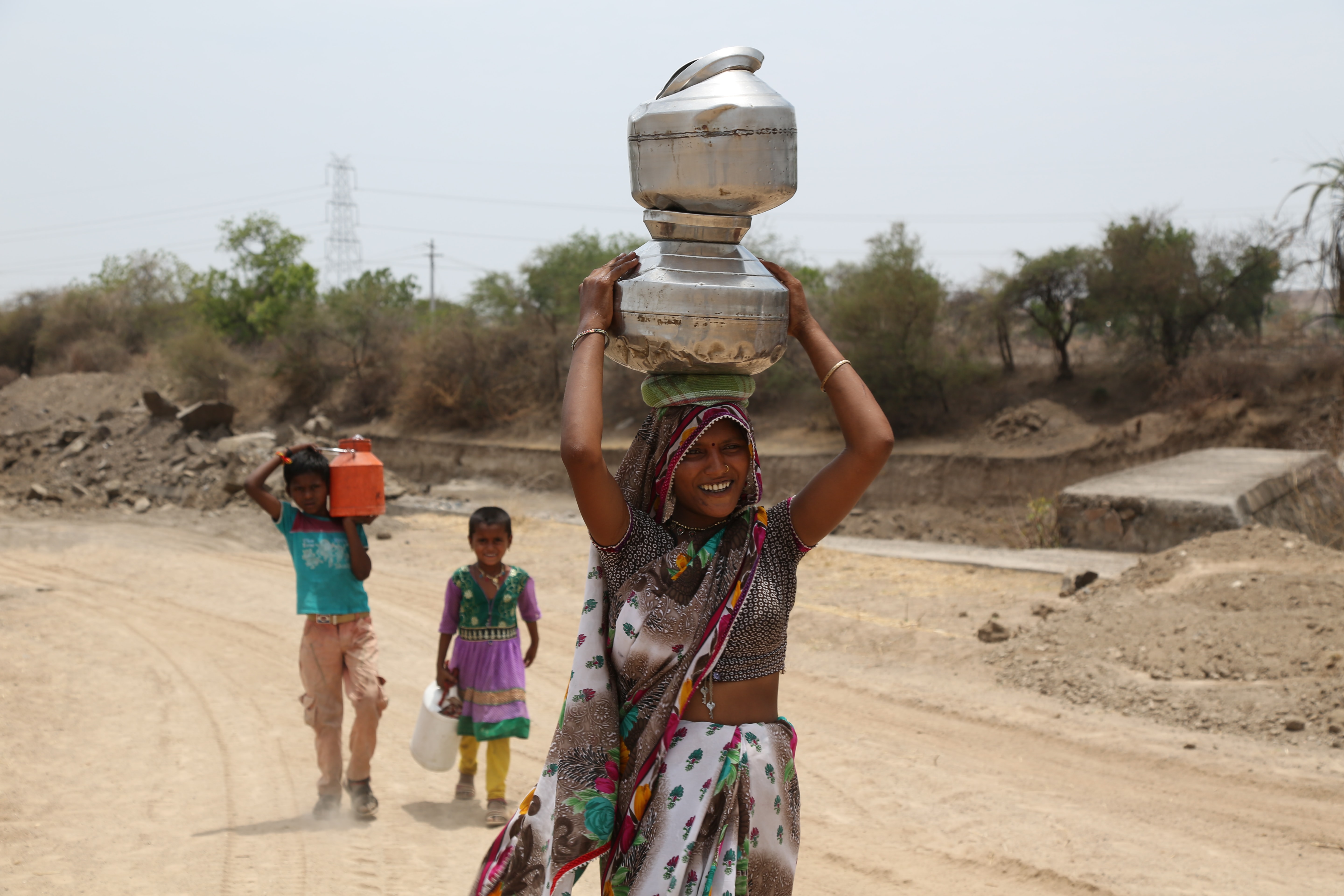 یک زن و چند کودک درحال حمل آب/ خشکسالی